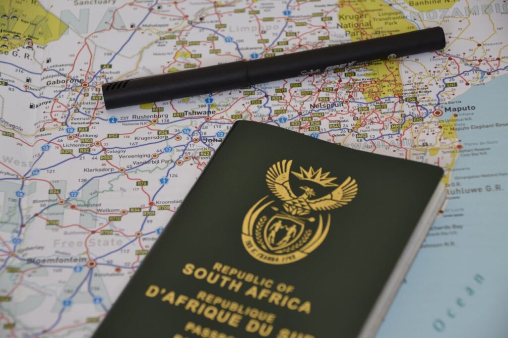 A South African passport rests on a detailed map, symbolizing travel and exploration.